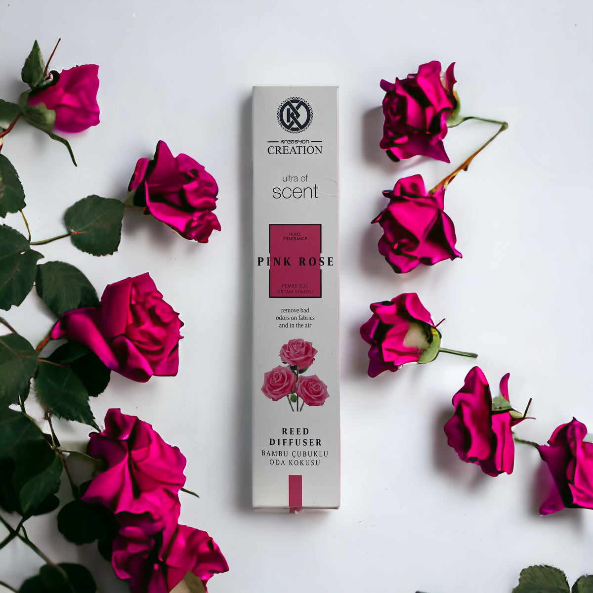 Rote Rose mit zartrosa Blüten, Duftöl-Flasche im Hintergrund, elegante Duftkerze für ein gemütliches Ambiente.